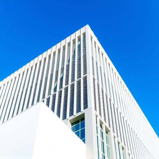 Photographie architecturale d'un bâtiment moderne avec des lignes graphiques et un ciel bleu en arrière-plan.